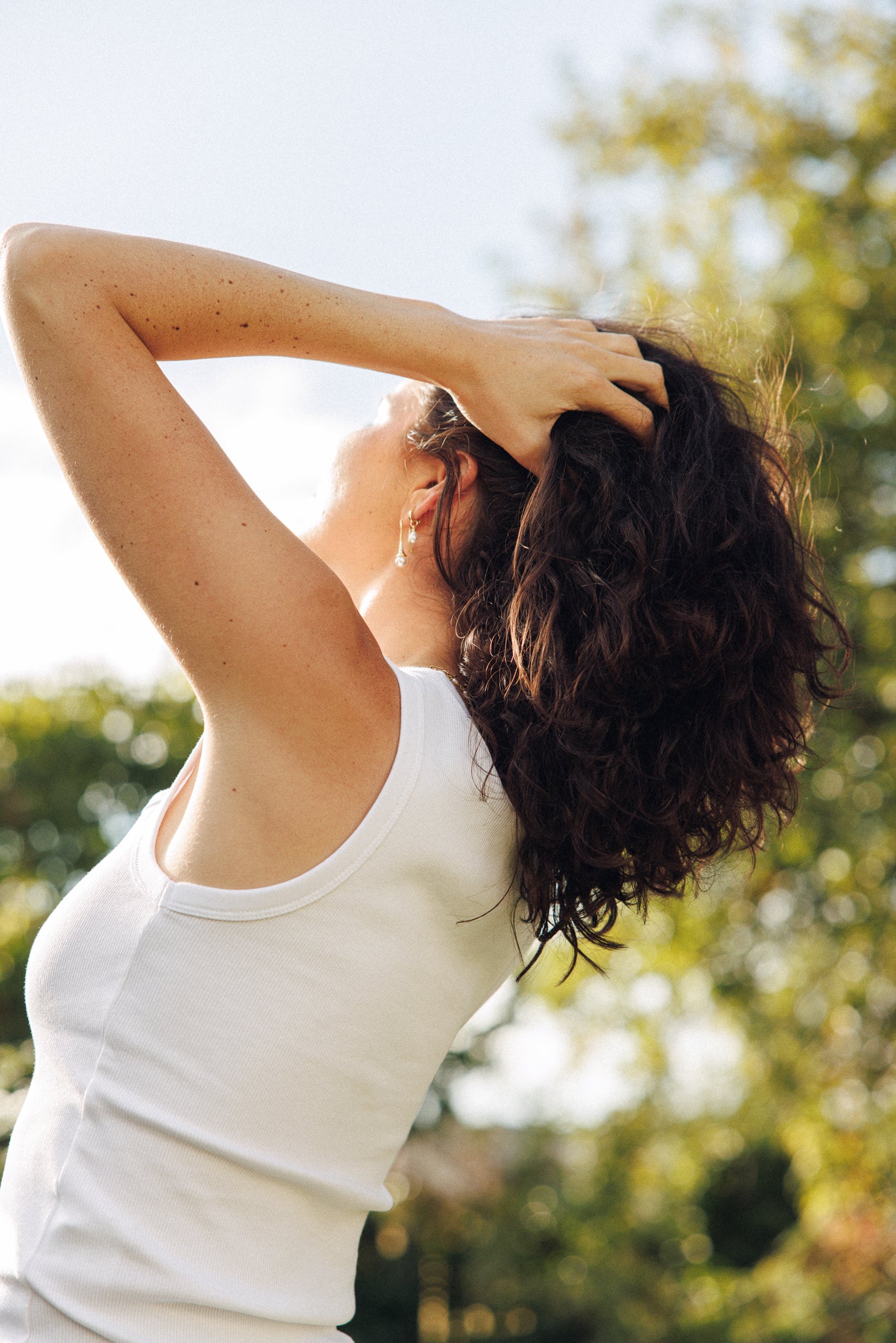 Woman stretching outdoors with trees in the background